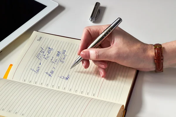 Vrouw schrijven en analyseren van financiële gegevens — Stockfoto