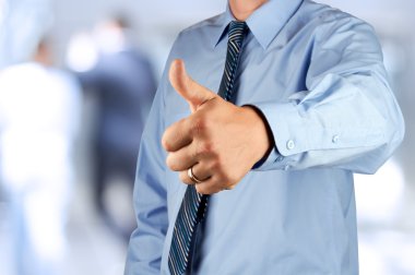 Baş parmağını ok işaretiyle gösterilen işadamı.