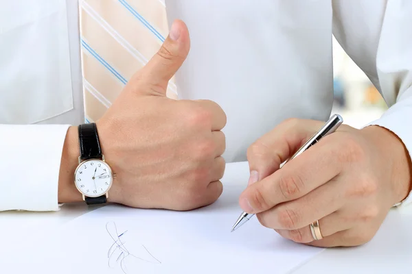 Empresario firmando un documento y mostrando OK signo con su thu — Foto de Stock