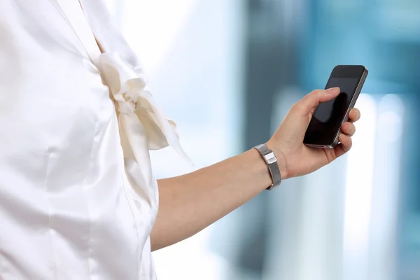 Geschäftsfrau hält und nutzt das Handy — Stockfoto