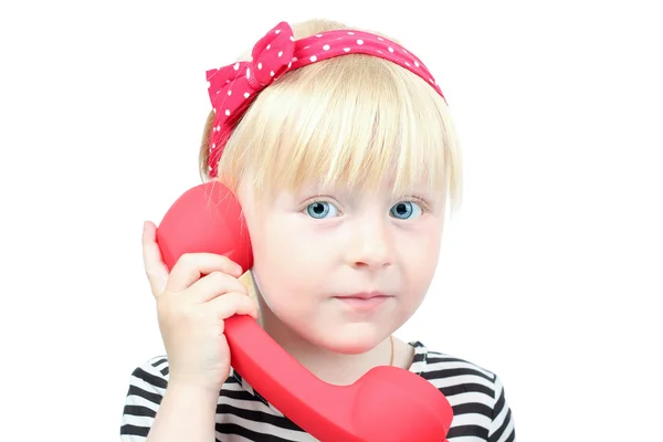 Bonita niña rubia con un teléfono retro rojo en un bac blanco — Foto de Stock