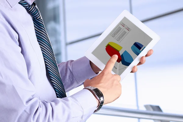 Бизнесмен держит в руках цифровой планшет и анализирует финансовые — стоковое фото