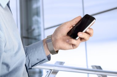 Holding ve mobil akıllı telefon kullanan iş adamı