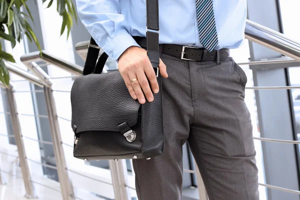 Businessman standing  and holding  a  leather briefcase on his s — Stock Photo, Image