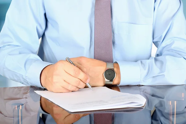 Businessman  sitting at office desk and  signing a contract  by — Stock Photo, Image