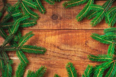 Noel arkaplanı. Ladin dalları ahşap bir zeminde yuvarlak bir çerçeve şeklinde dallanır.