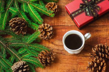 Noel arkaplanı. Spruce dalları, hediye konileri ve tahta zemin üzerinde kahve olan bardaklar. Boşluğu, çerçeveyi, metin için yeri kopyala. Üst Manzara. Noel ya da yeni yıl kartı. düz yat