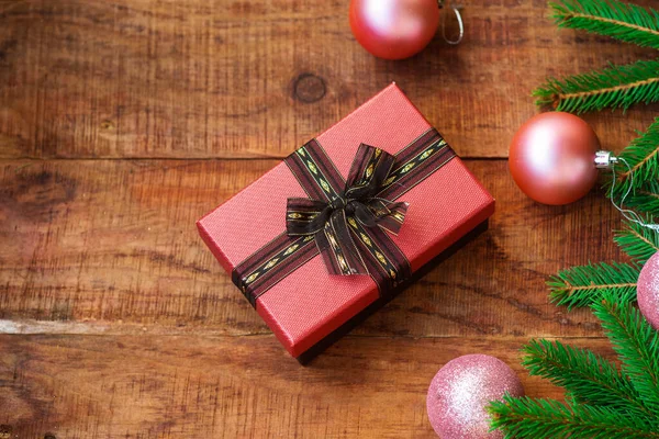 Різдвяний фон. Рожеві різдвяні кульки, подарункові та ялинові гілки на дерев'яному тлі. Копіювати пробіл, кадр — стокове фото