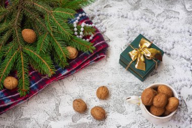 Yeni yıl veya Noel kompozisyonu ladin yeşili dallar, kırmızı ekose, ceviz, hediye ve parlak bir dokuma arka planda noel lolipopları. Düz konum, düzen, çerçeve, kopyalama alanı