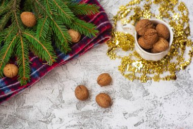 Yeni yıl ya da noel kompozisyonu ladin yeşili dallar, kırmızı ekose ve fındıklı parlak desenli fındık. Düz konum, düzen, çerçeve, kopyalama alanı