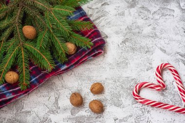 Yeni yıl ya da Noel kompozisyonu ladin yeşili dallar, kırmızı ekose ve Noel lollipopson parlak bir yapısal altyapı. Düz konum, düzen, çerçeve, kopyalama alanı