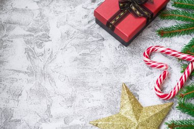 Yeni yıl ya da noel kompozisyonu ladin yeşili dallar, yeni yıl yıldızı, hediye, kurabiye ve parlak bir dokuma arka planda noel lolipopları. Düz konum, düzen, kopyalama alanı