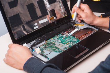 Sihirbaz dizüstü bilgisayarı aletler ve ellerle tamir eder