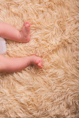 Yeni doğmuş bir bebeğin çıplak bacakları yumuşak, hafif, bir tonluk, sıcak bir örtü. Sevimli yeni doğmuş bebek ayakları Yaklaş