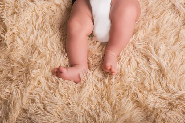 Голі ноги новонародженого на пухнастому, легкому, однотонному, теплому покритті. Симпатичні новонароджені ноги крупним планом — стокове фото