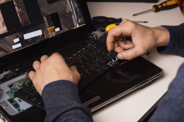 Sihirbaz dizüstü bilgisayarı aletler ve ellerle tamir eder