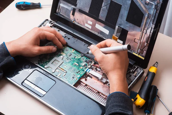 Майстер ремонтує ноутбук за допомогою інструментів і рук — стокове фото