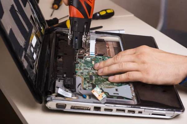 Wizard répare ordinateur portable avec des outils et des mains — Photo