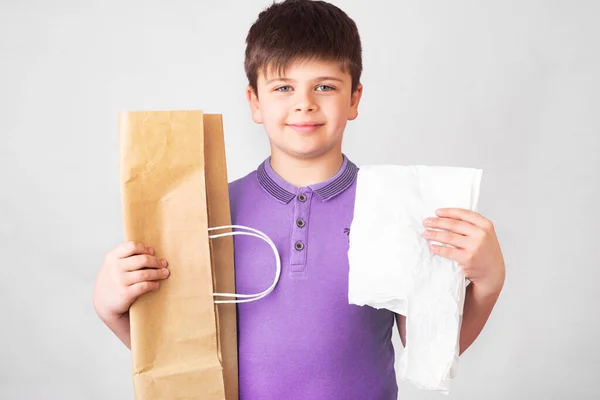 돈으로 종이와 비닐봉지를 귀여운 소년은 생태학적 제품을 선호하고 무엇을 선택하는지를 — 스톡 사진