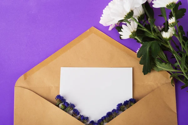 Otwarta Koperta Papieru Rzemieślniczego Pustym Kawałkiem Papieru Suszonych Niebieskich Kwiatów — Zdjęcie stockowe