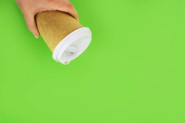 Φλιτζάνι καφέ επαναχρησιμοποιήσιμα υλικά στο χέρι σε πράσινο φόντο. έννοια μηδενικών αποβλήτων. αντικατάσταση για πλαστικά ποτήρια — Φωτογραφία Αρχείου