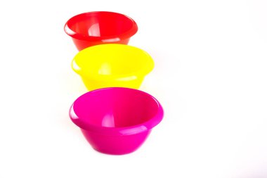 Beyaz arka planda farklı renklerde plastik yuvarlak kaseler. Kuru malzemeler için mutfak kapları. Montessori maçları için kase. Kapasiteler sınıflandırılıyor. İzole et. Boşluğu kopyala, üst görünüm