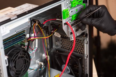 Siyah eldivenli büyücü kişisel bilgisayarı restore eder. Bilgisayarın yedek parçalarına ayrılması. Aletleri kullanarak bilgisayar ekipmanlarının bakımı. İçerideki bilgisayar görüntüsü. comp servisi