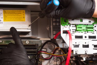 Siyah eldivenli büyücü kişisel bilgisayarı restore eder. Bilgisayarın yedek parçalarına ayrılması. Aletleri kullanarak bilgisayar ekipmanlarının bakımı. İçerideki bilgisayar görüntüsü. comp servisi