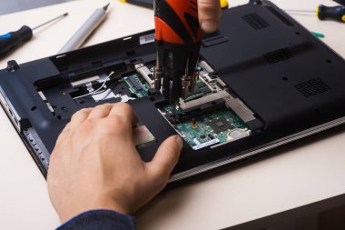 Sihirbaz dizüstü bilgisayarı restore eder. Dizüstü bilgisayarın yedek parçalarına ayrılması. Tahta, iyileşme için dizüstü bilgisayarın bir parçası. Aletleri kullanarak bilgisayar ekipmanlarının bakımı. İçerideki dizüstü bilgisayara bak