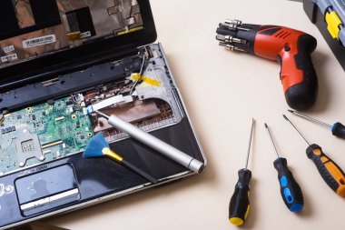 Sihirbaz dizüstü bilgisayarı restore eder. Dizüstü bilgisayarın yedek parçalarına ayrılması. Tahta, iyileşme için dizüstü bilgisayarın bir parçası. Aletleri kullanarak bilgisayar ekipmanlarının bakımı. İçerideki dizüstü bilgisayara bak