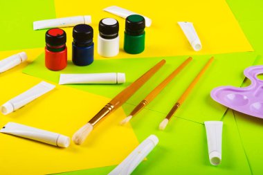 Yaratıcılığa ayarlı. Boyalı kavanozlar ve tüpler, Molbert. Çok renkli kağıtların arka planına çizim için fırçalar. Üst Manzara. Sanat yaratıcısı. resim dersi