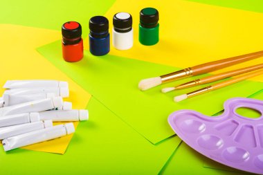 Yaratıcılığa ayarlı. Boyalı kavanozlar ve tüpler, Molbert. Çok renkli kağıtların arka planına çizim için fırçalar. Üst Manzara. Sanat yaratıcısı. resim dersi