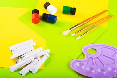 Yaratıcılığa ayarlı. Boyalı kavanozlar ve tüpler, Molbert. Çok renkli kağıtların arka planına çizim için fırçalar. Üst Manzara. Sanat yaratıcısı. resim dersi