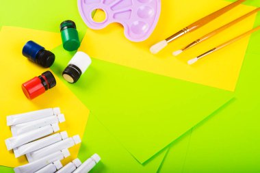 Yaratıcılığa ayarlı. Boyalı kavanozlar ve tüpler, Molbert. Çok renkli kağıtların arka planına çizim için fırçalar. Üst Manzara. Sanat yaratıcısı. resim dersi