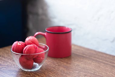 Dolu kremalı fındık şeklinde çok renkli kurabiyeler ve ahşap bir masada bir fincan kahve. Ev yapımı kurabiyeler. Uzayı kopyala Lezzetli tatlılar.
