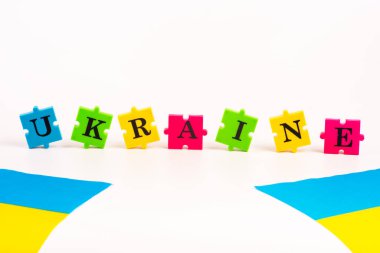 Ukrayna 'nın renkli mavi-sarı bayrağı ve beyazın üzerinde Ukrayna' nın izole ettiği mektup bulmacaları. Devletin sembolü. Uzayı kopyala Ulusal Flama