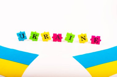 Ukrayna 'nın renkli mavi-sarı bayrağı ve beyazın üzerinde Ukrayna' nın izole ettiği mektup bulmacaları. Devletin sembolü. Uzayı kopyala Ulusal Flama