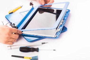 The engineer repairs blue laptop, pc, computer and the screen in the white background. laptop screen replacement. Installs the equipment, cpu. isolated