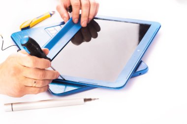 The engineer repairs blue laptop, pc, computer and the screen in the white background. laptop screen replacement. Installs the equipment, cpu. isolated