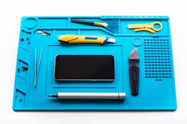 Bozuk akıllı telefonun bazı parçaları tamir etmek ya da değiştirmek için sökülmesinin düz bir görüntüsü vardı. Hasarlı bir cep telefonunu tamir ediyorum. Akıllı Telefon Tamir Aletleri. Üst görünüm