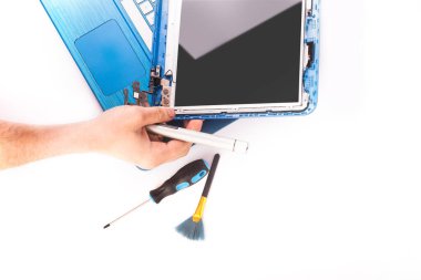 The engineer repairs blue laptop, pc, computer and the screen in the white background. laptop screen replacement. Installs the equipment, cpu. isolated