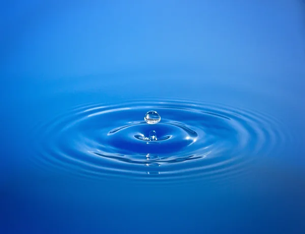 Gota isolada em água azul — Fotografia de Stock