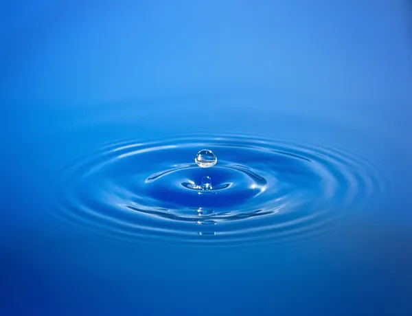 Drop isolated in blue water Stock Photo