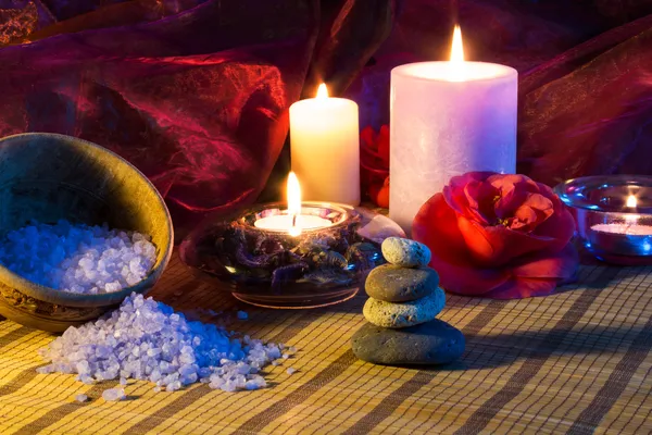 Four candles camellias stones and salt — Stock Photo, Image