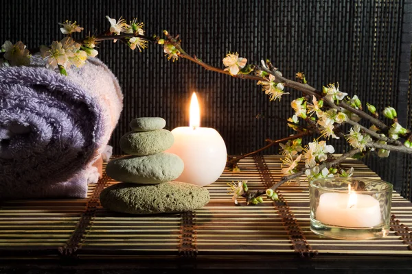 Almond flowers with candles and white stones — Stock Photo, Image