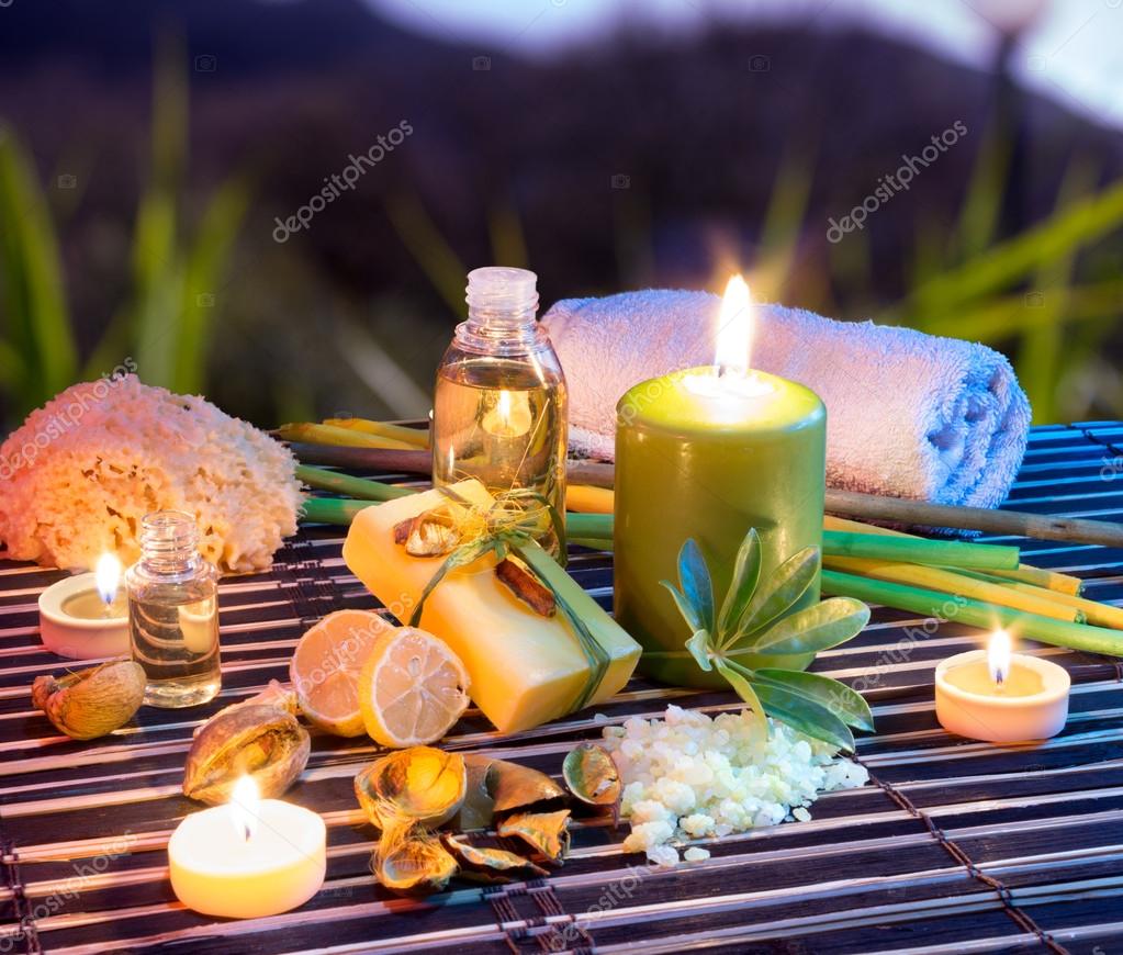 Lemon soap , oil, towel, salt and candles in garden ⬇ Stock Photo