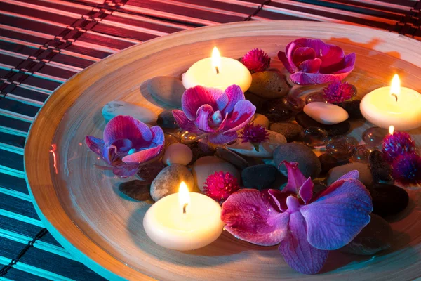 Dish Spa mit schwimmenden Kerzen, Orchidee auf Matte — Stockfoto