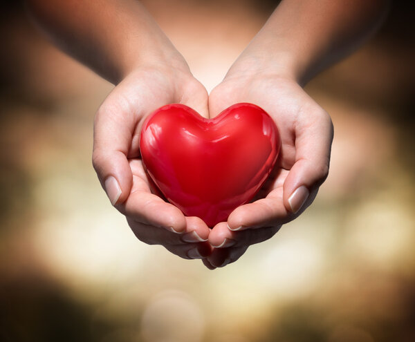 Heart in heart hands- warm background Royalty Free Stock Images
