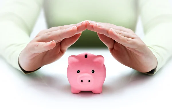 Protect your savings - with his hands covering the piggy bank — Stock Photo, Image