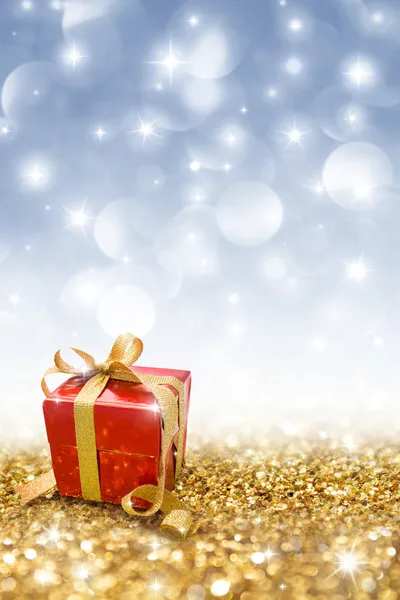 Red gift on golden glitter — Stock Photo, Image